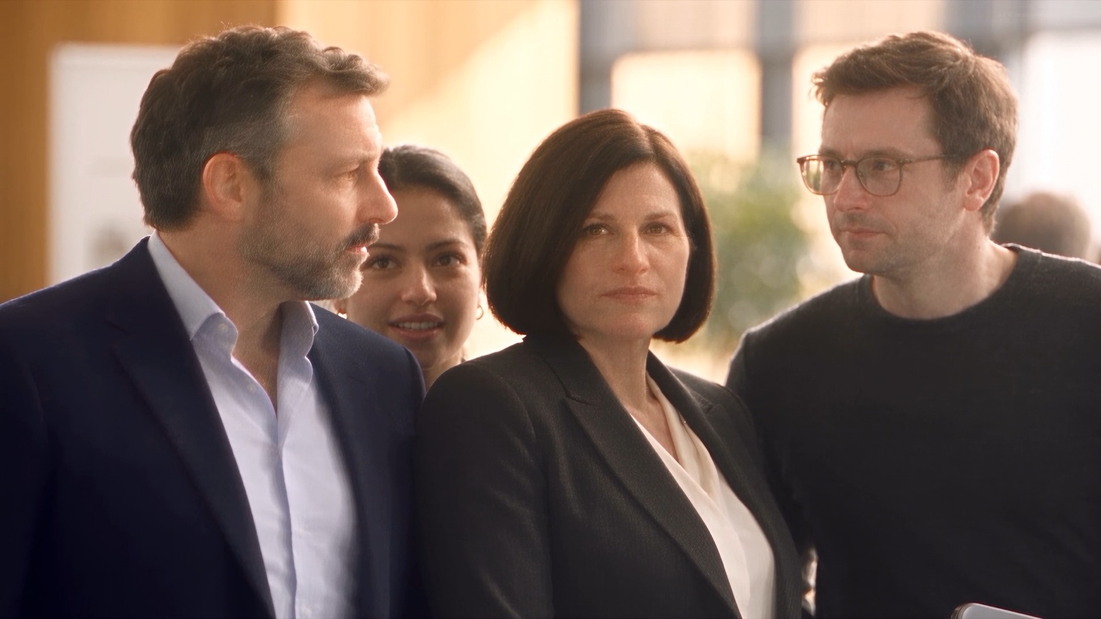 Four colleagues pause after posing together for a partner photograph
